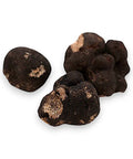 Fresh winter truffle Tuber Brumale B-grade with three black truffles on display